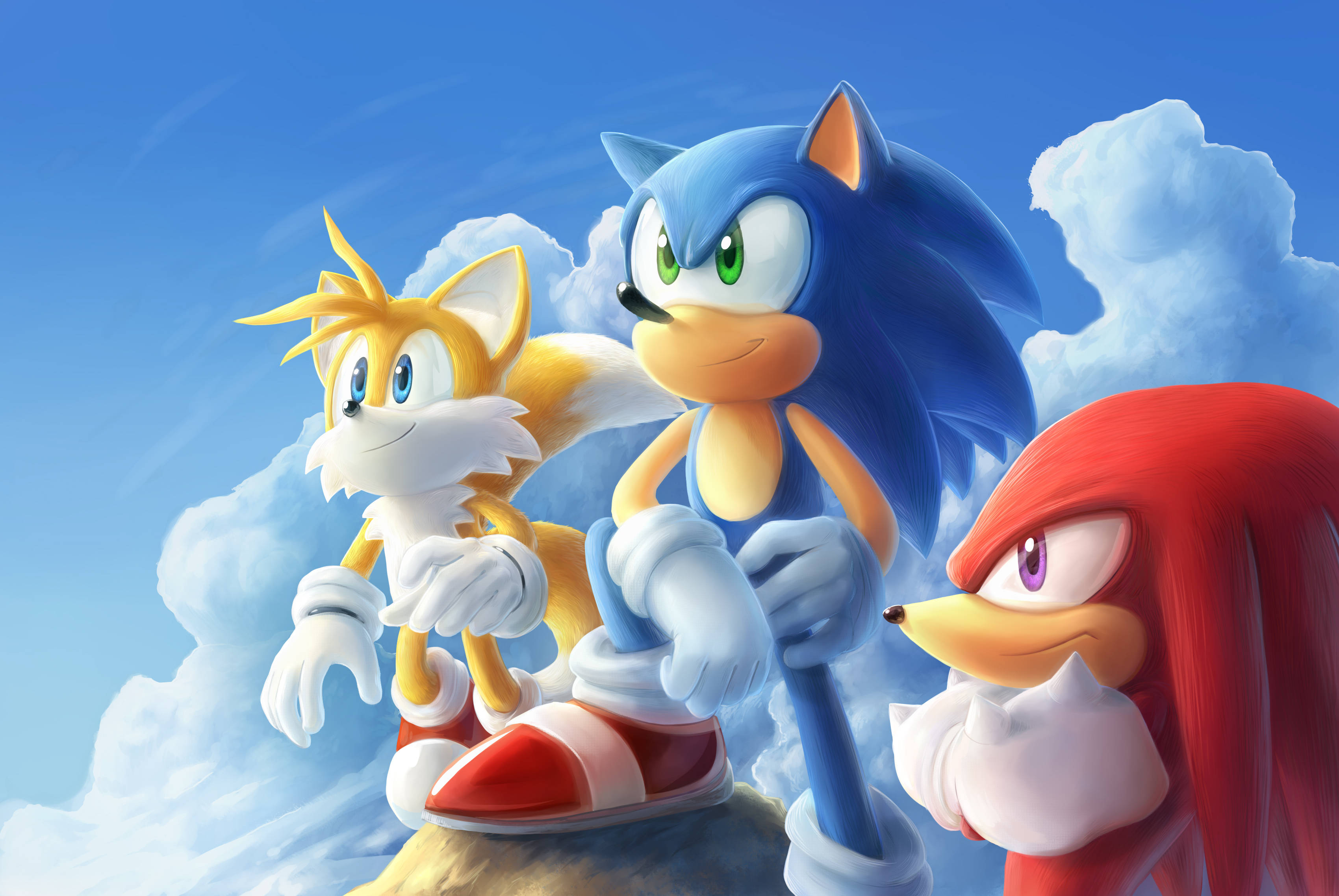Knuckles 桌布 壁紙 — Sonic、Tails 和 Knuckles 英雄般地站在懸崖頂上，背景是晴朗的藍天和蓬鬆的白雲。