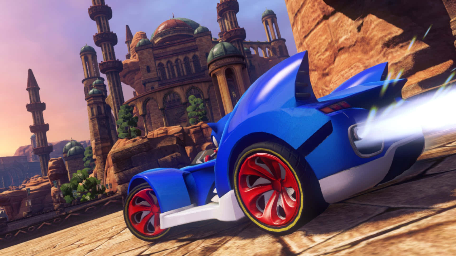 Sonic And All-stars Racing Transformed 桌布 壁紙 — Sonic the Hedgehog 駕駛一輛藍紅相間的汽車，在日落時分穿越擁有古老圓頂建築的沙漠峽谷。