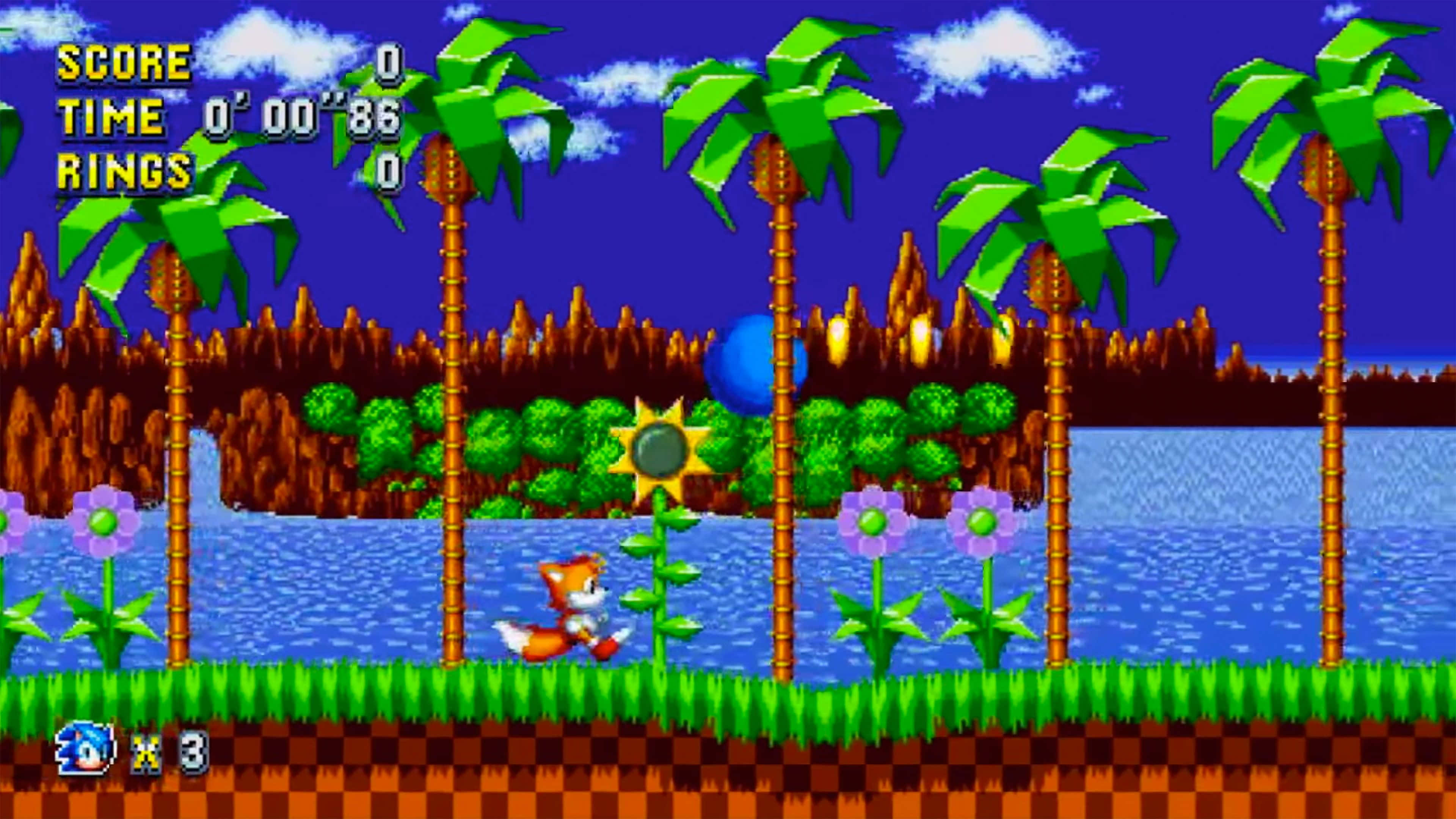 Sonic Angel Island 桌布 壁紙 — Sonic the Hedgehog 在陽光明媚的天空下，穿過一個充滿活力的像素化叢林關卡，有棕櫚樹和藍色水。