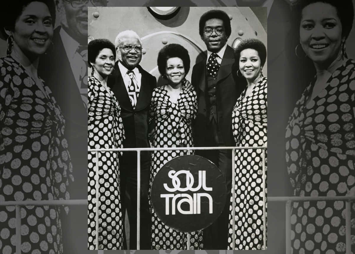 American 桌布 壁紙 — Soul Train 演員在品牌舞台前微笑的黑白照片，穿著圓點連衣裙和西裝。
