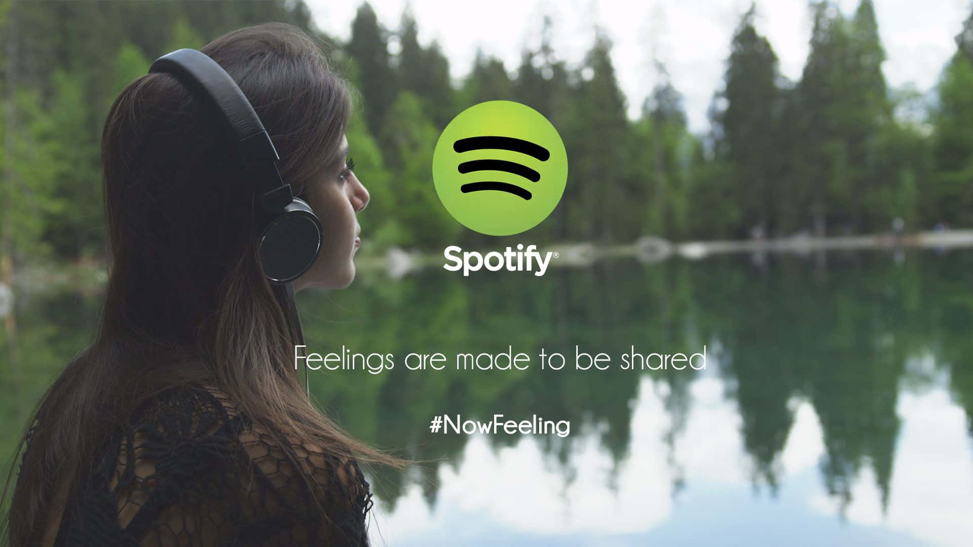 Spotify - 一位戴著耳機的女性站在湖邊 壁紙