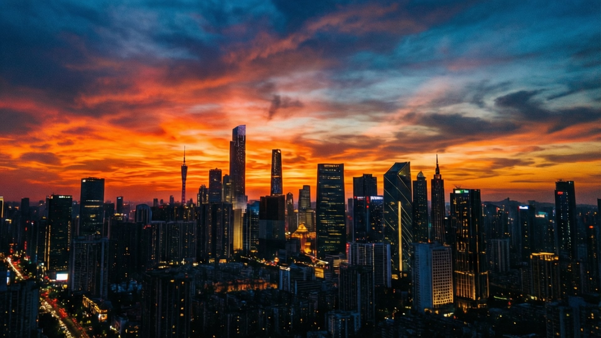 Urban Sunset Skyline 壁紙 — 黃昏時分，廣闊的城市天際線，火橙色和深藍色的雲層籠罩在高聳的摩天大樓之上。
