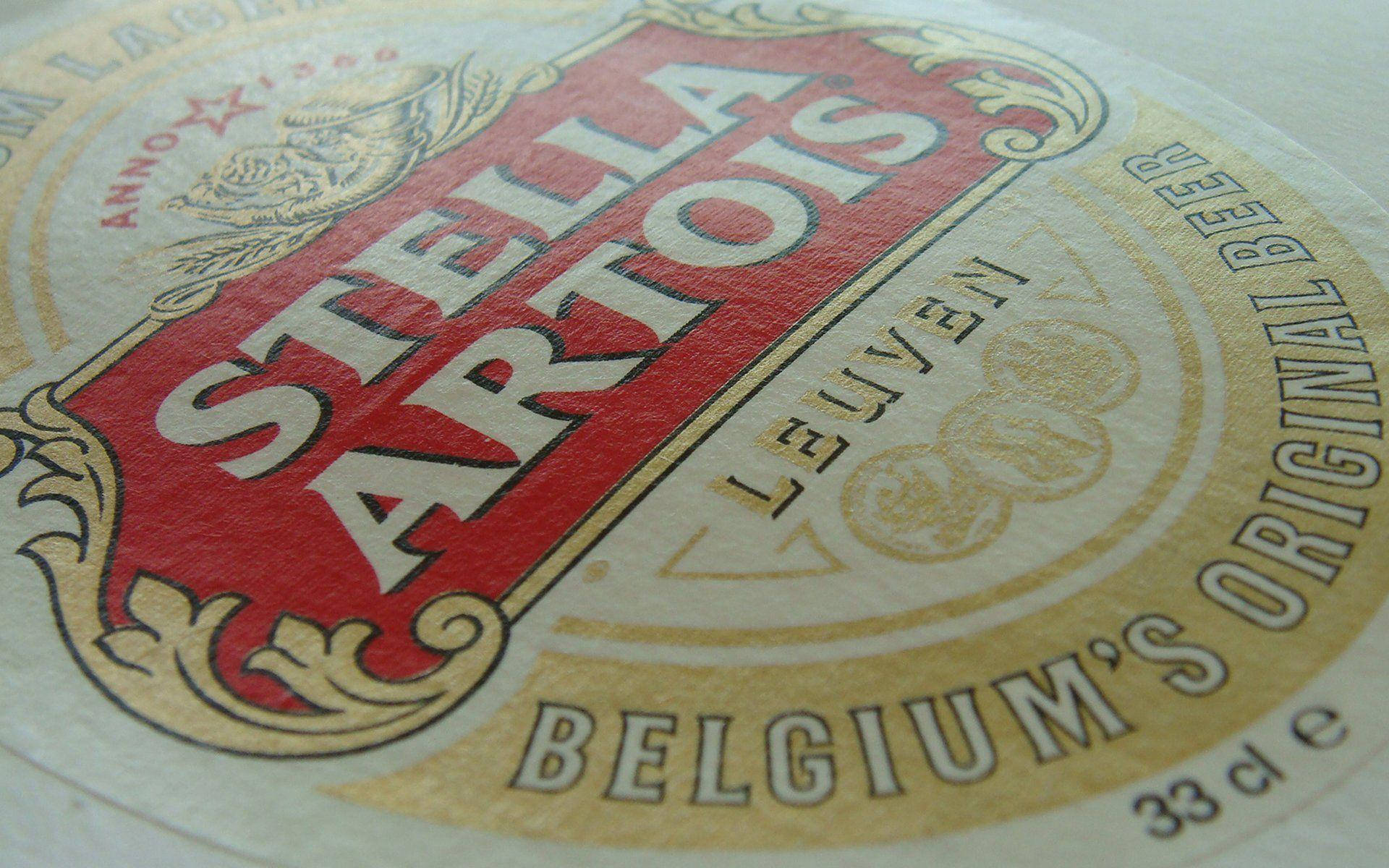 飲料 桌布 壁紙 — Stella Artois 啤酒標籤的特寫，帶有紅色、金色和奶油色，展示複雜的復古字體和徽章設計。