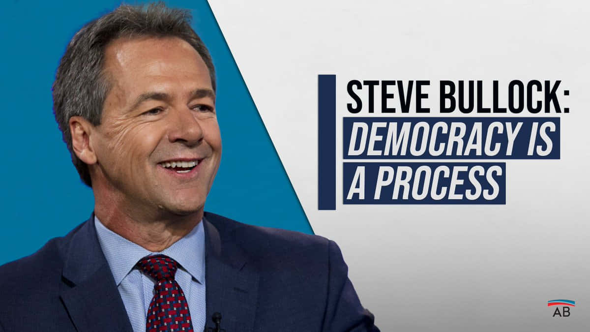 政治 桌布 壁紙 — Steve Bullock 穿著西裝，在藍白圖形背景上以粗體文字寫著「Democracy is a Process」，溫暖地微笑。