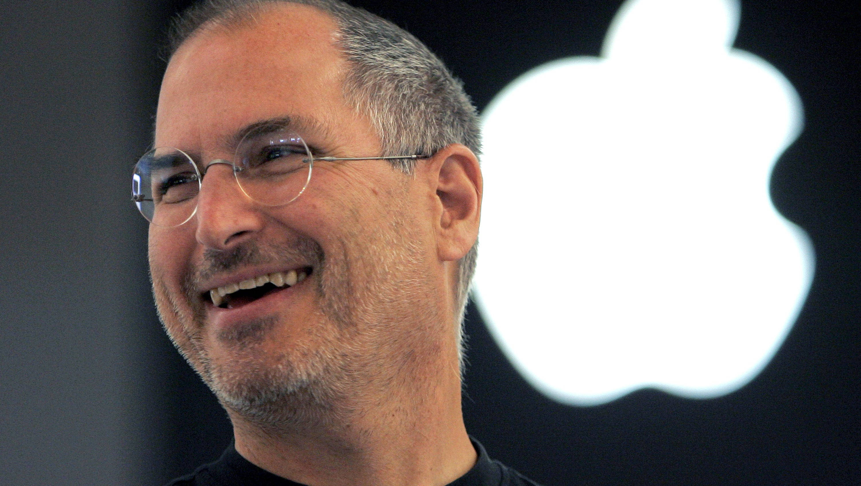 Rich 桌布 壁紙 — Steve Jobs 在產品發表會上於發光的 Apple 標誌前溫暖地大笑。