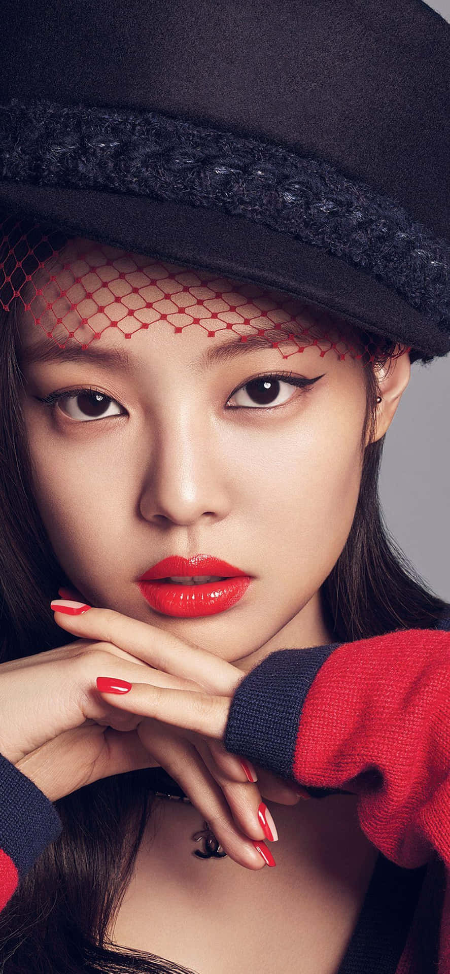 戴著黑色帽子、紅色網紗和紅色唇膏的女性為相機擺姿勢。 — Blackpink 壁紙