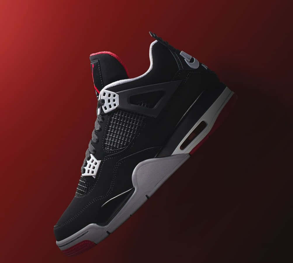 黑紅Jordan 4運動鞋，帶有白色點綴，背景為紅色漸變。 — Air Jordan 壁紙