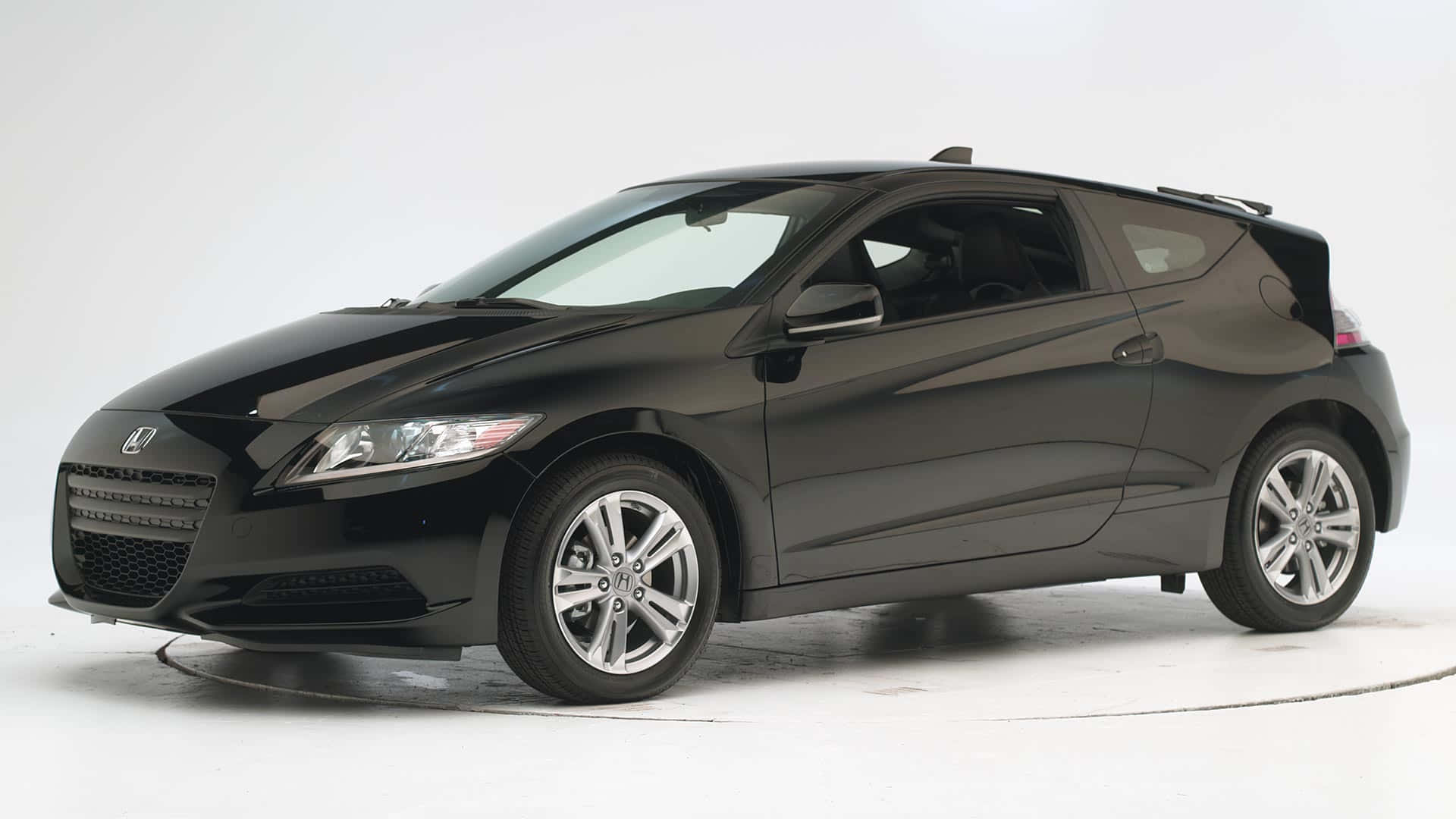 Honda Cr-z 桌布 壁紙 — 一輛時尚的黑色本田CR-Z運動轎跑車，在工作室燈光下展示，帶有反光表面和銀色合金輪圈。