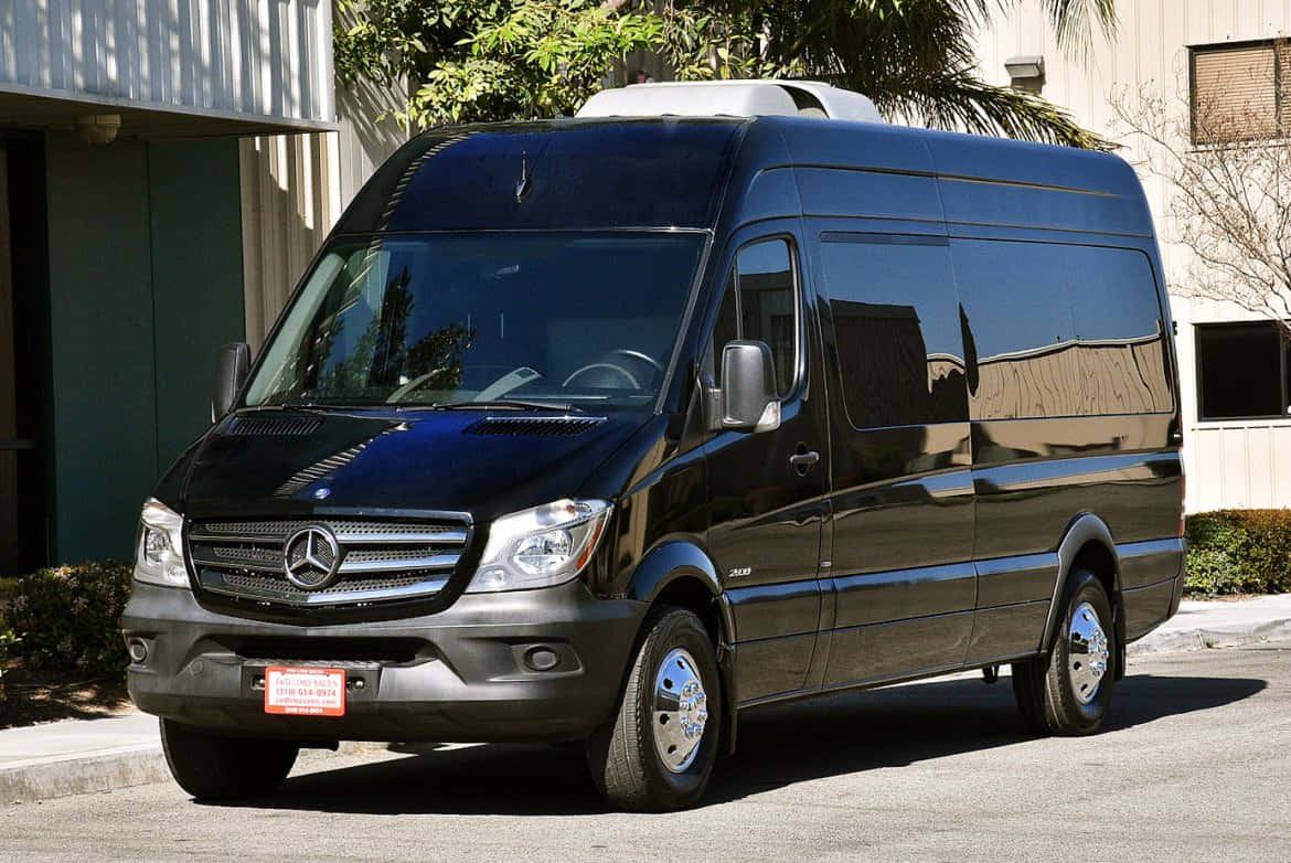 Mercedes Benz Sprinter 桌布 壁紙 — 一輛時尚的黑色 Mercedes-Benz Sprinter 客貨車停放在陽光明媚的街道上，背景有棕櫚樹和建築物。