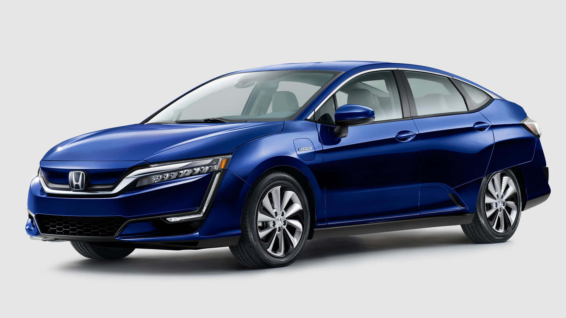 Honda Clarity 桌布 壁紙 — 一輛時尚的藍色本田Clarity插電式混合動力轎車，在攝影棚燈光下以潔白背景展示。