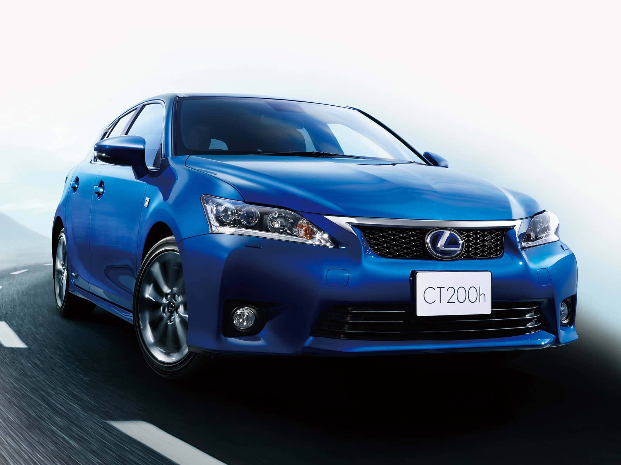 Lexus Ct 200h 桌布 壁紙 — 一輛時尚的藍色Lexus CT200h轎車在明亮的攝影棚燈光下，沿著模糊的道路疾馳。