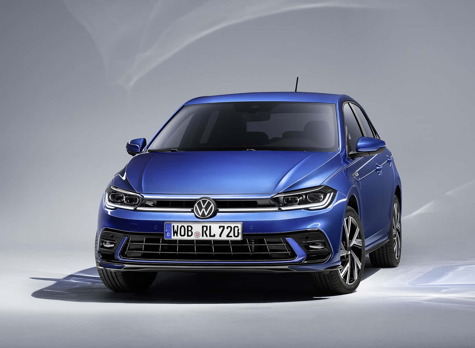 Volkswagen Polo 桌布 壁紙 — 時尚的藍色福斯 Polo R-Line 轎車在簡約灰色背景前於攝影棚燈光下閃耀。