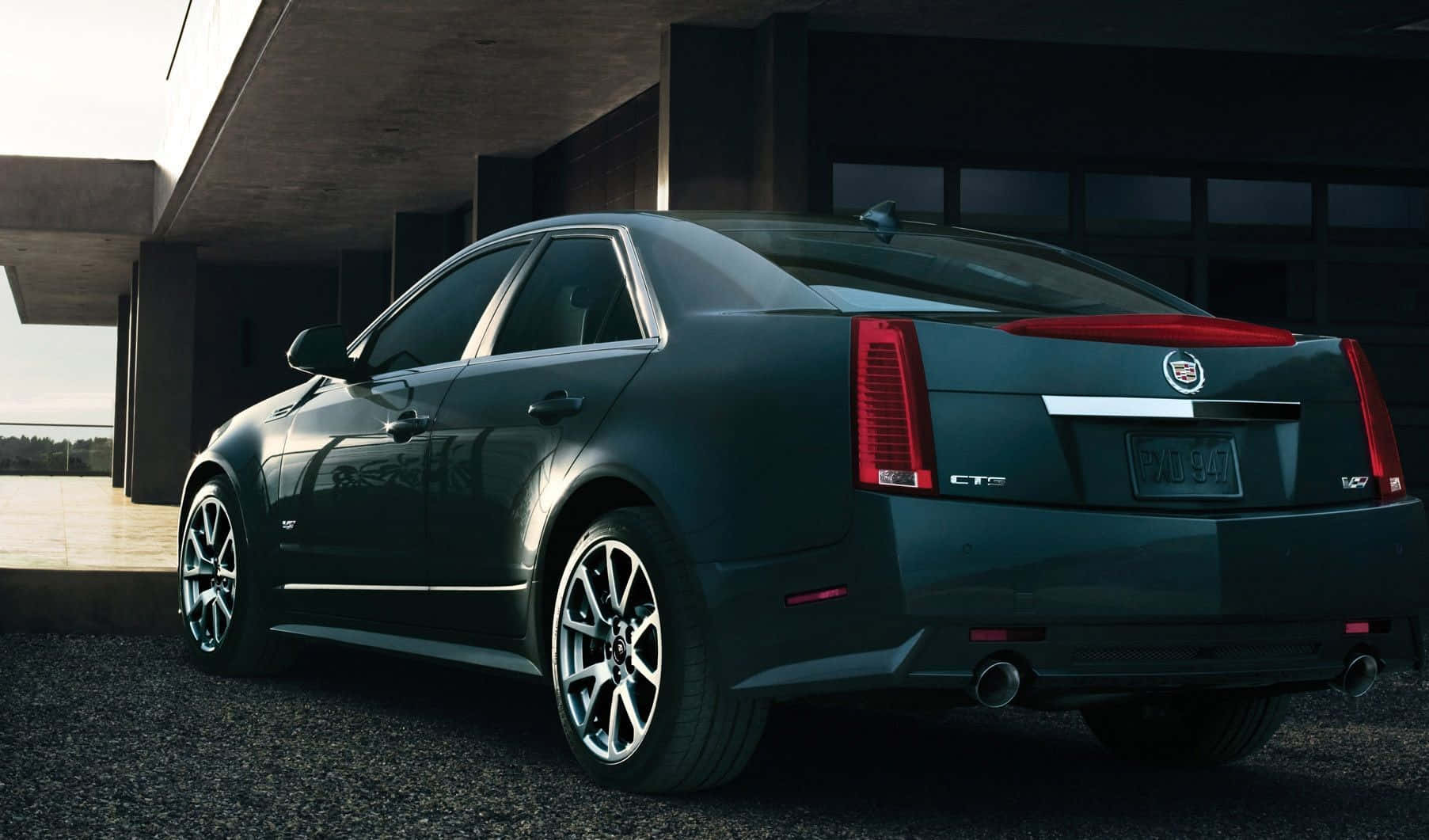 Cadillac Cts 桌布 壁紙 — 一輛時尚的深綠色 Cadillac CTS-V 轎車停放在現代混凝土結構下，配以戲劇性的燈光。