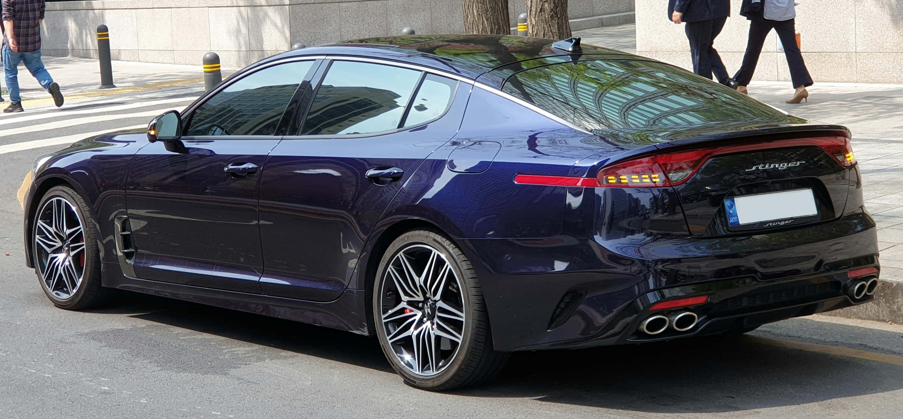 Kia Stinger 桌布 壁紙 — 一輛時尚的深紫色Kia Stinger運動型轎車停放在城市街道上，有行人走過。