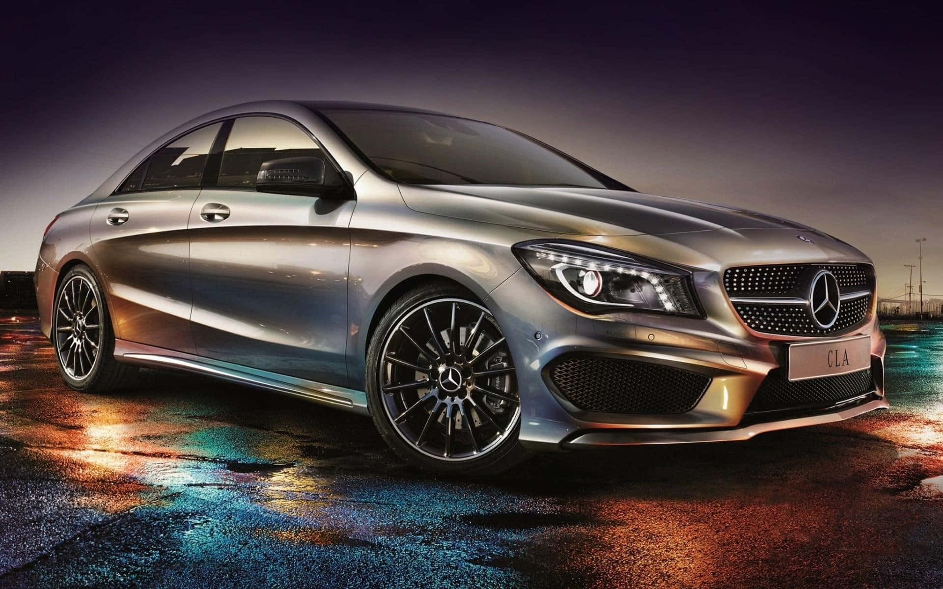 Mercedes Benz Cla-class 桌布 壁紙 — 一輛時尚的銀色 Mercedes-AMG CLA 轎車在戲劇性的燈光下，於濕漉漉的城市街道上閃耀，反射出霓虹色彩。