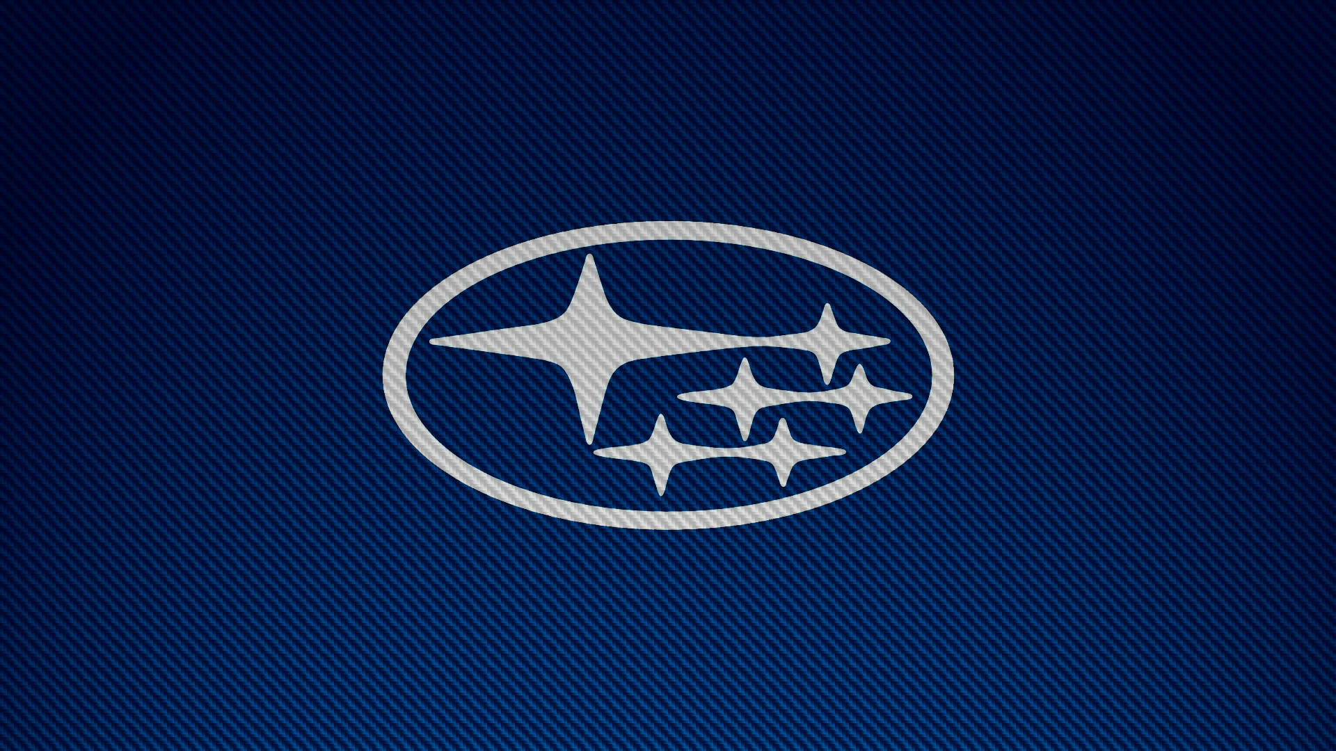 Subaru Logo 桌布 壁紙 — Subaru 標誌，銀色橢圓形內有四顆星，置於帶紋理的藍色碳纖維背景上。
