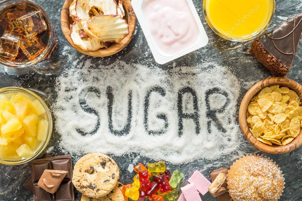 Sugar 桌布 壁紙 — 「SUGAR」一詞用砂糖拼寫，周圍是甜食，放在深色檯面上。