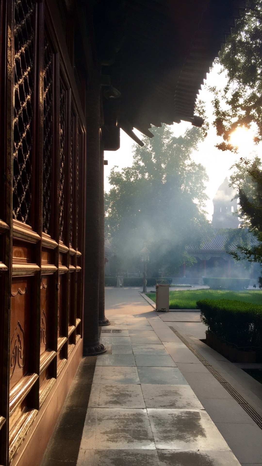 Mist at the Great Mosque 壁紙 — 陽光穿過樹木，在霧氣瀰漫的庭院和華麗的木製寺廟門旁投下金色光芒。