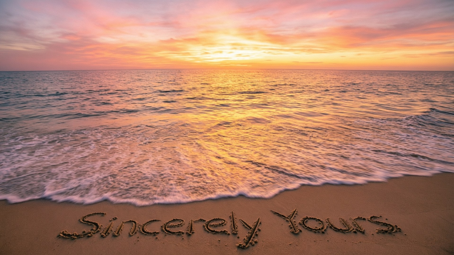 Sincerely Yours 桌布 壁紙 — 夕陽將海洋染成溫暖的金色和粉紅色，溫柔的海浪拍打著沙灘，沙灘上寫著「Sincerely Yours」。