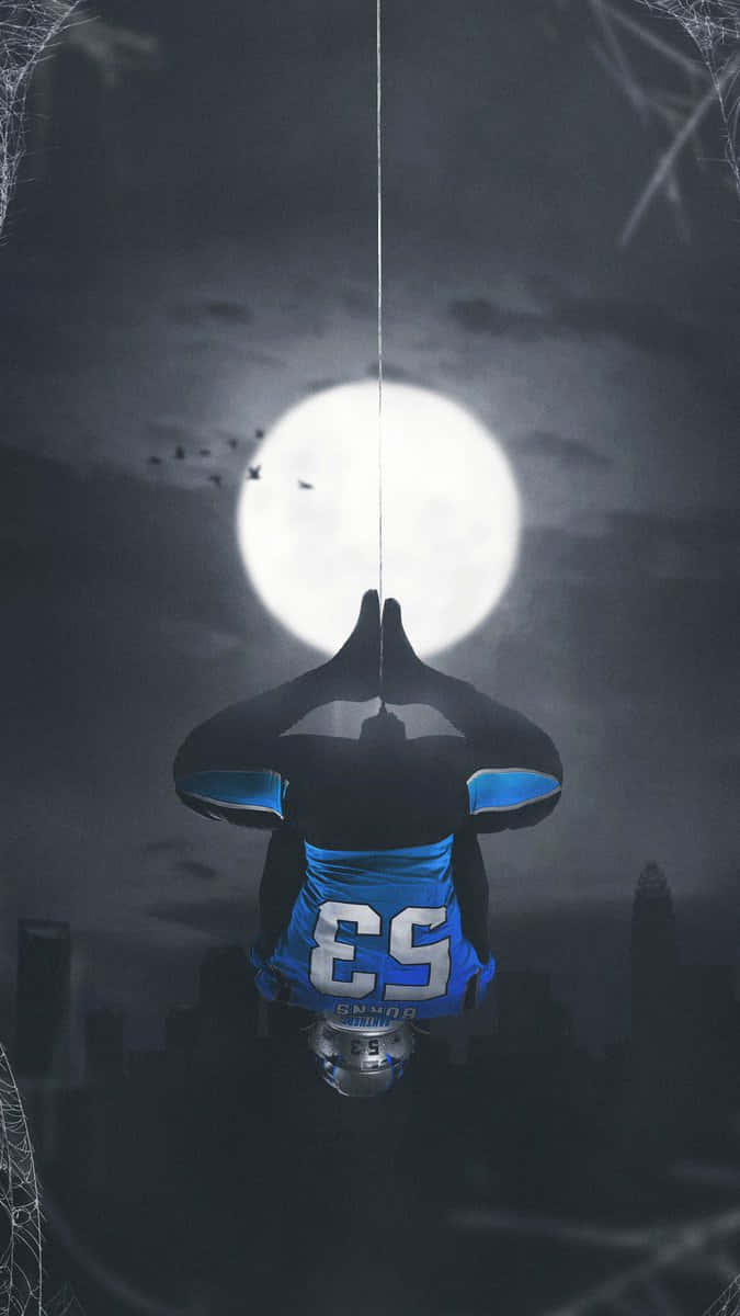  壁紙 — 一位身穿藍黑戰衣的超級英雄倒掛在蜘蛛網上，背景是城市天際線上的滿月。