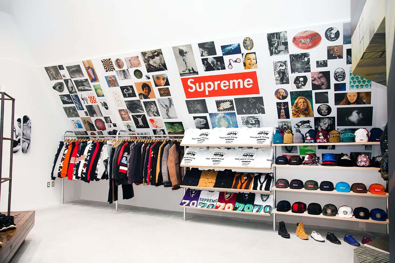 supreme 桌布 壁紙 — Supreme 商店內部，設有色彩繽紛的街頭服飾架和帽子架，牆上覆蓋著拼貼藝術和品牌的紅色標誌。
