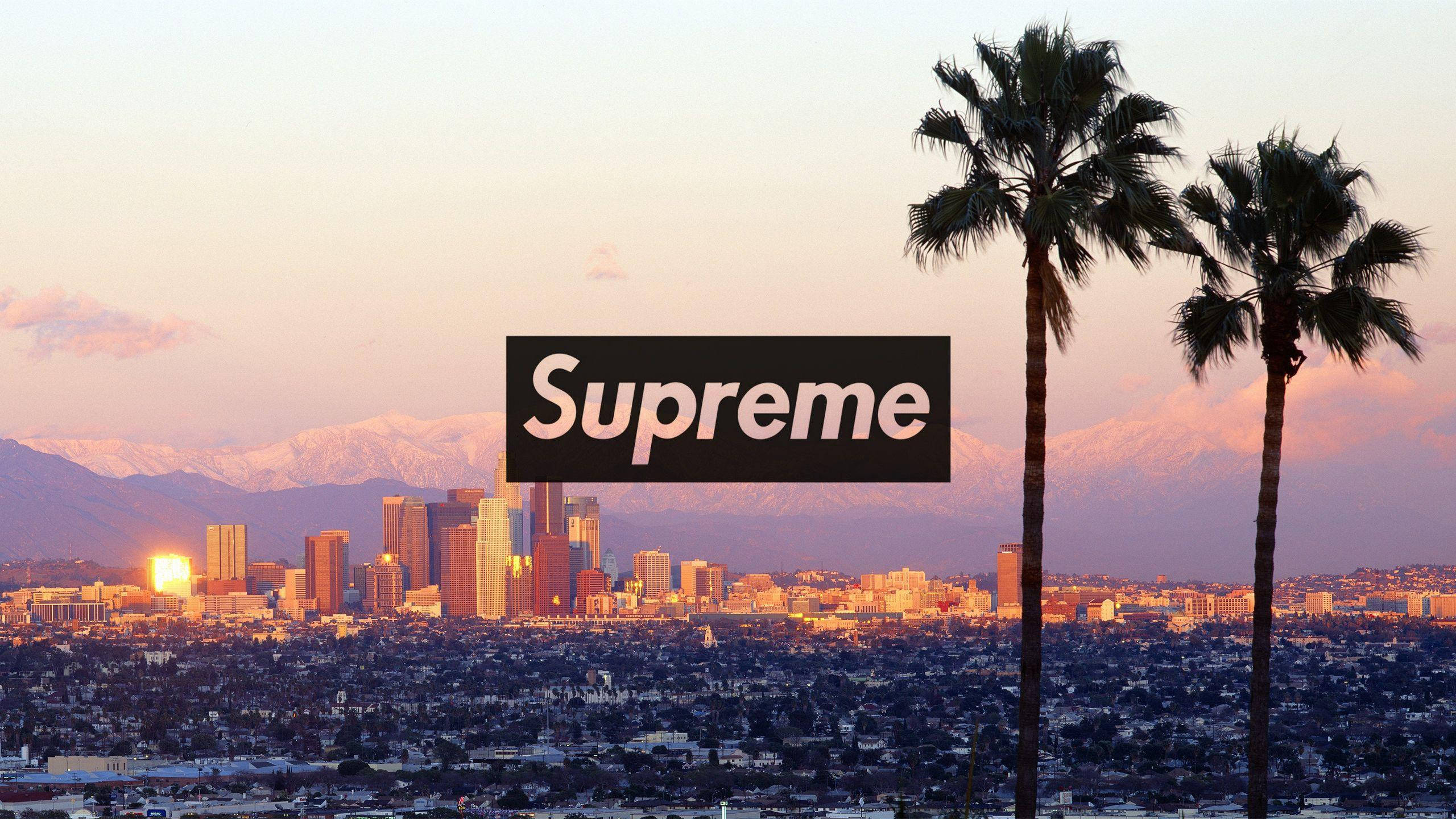 城市 桌布 壁紙 — Supreme 標誌漂浮在日落時分的城市天際線上，背景有棕櫚樹和雪山。