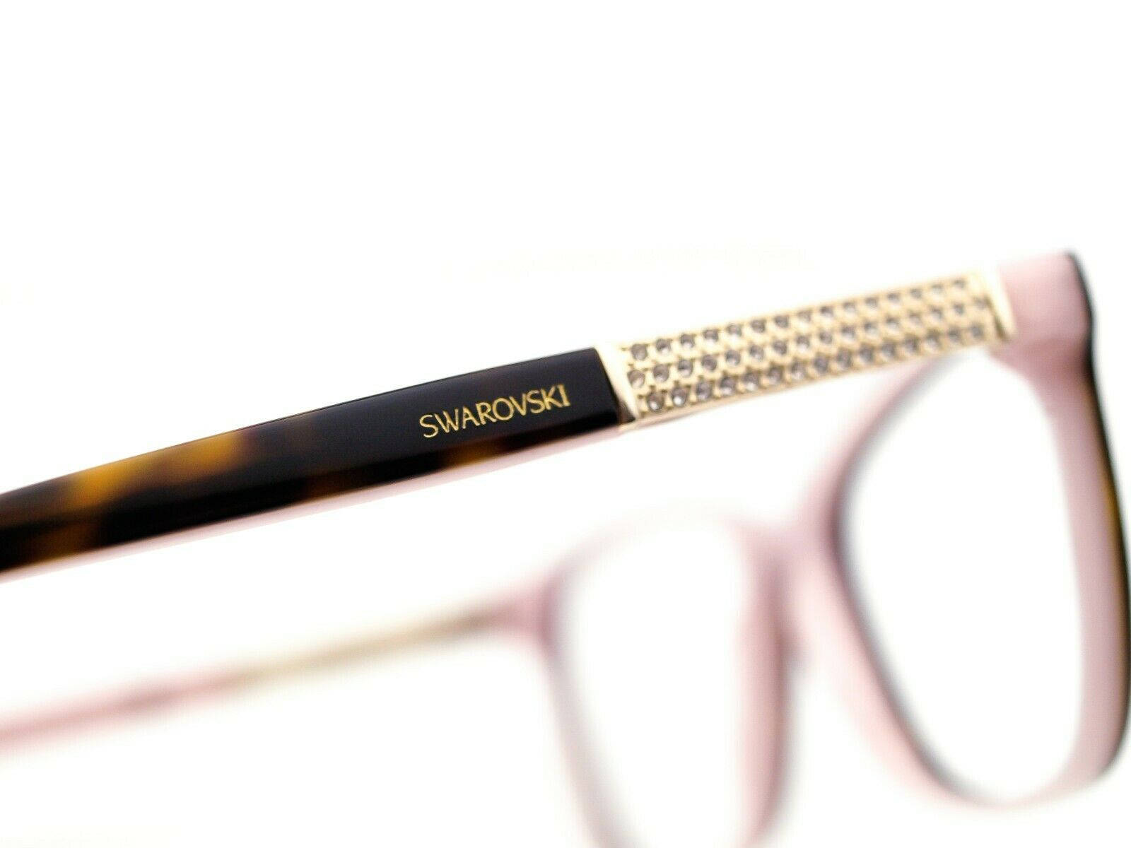 品牌 桌布 壁紙 — Swarovski 眼鏡框特寫，帶有龜甲紋理和鑲嵌水晶的金色鏡腿，背景為亮白色。