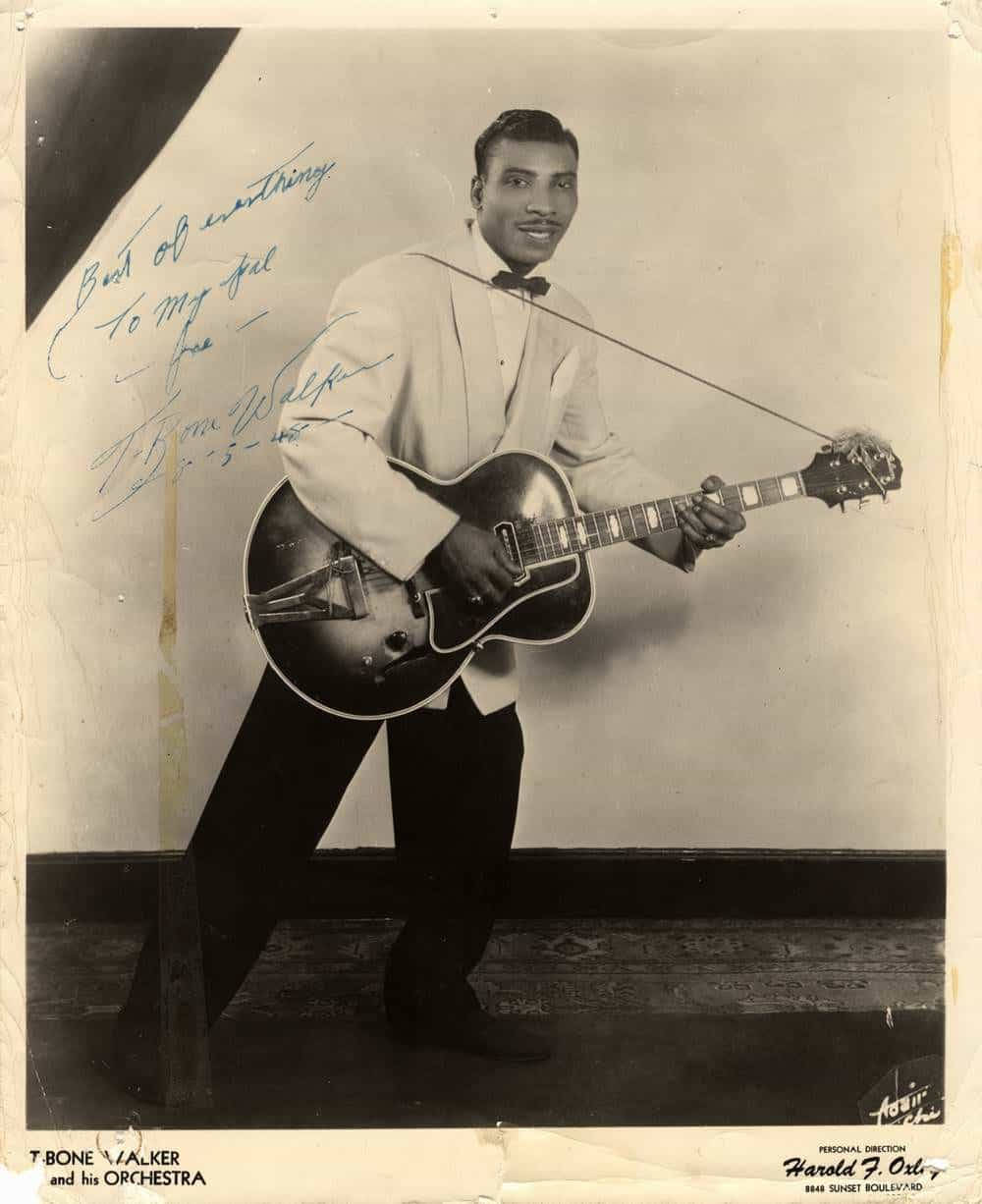 poster 桌布 壁紙 — T Bone Walker 在攝影棚內微笑手持拱頂吉他的復古黑白肖像。