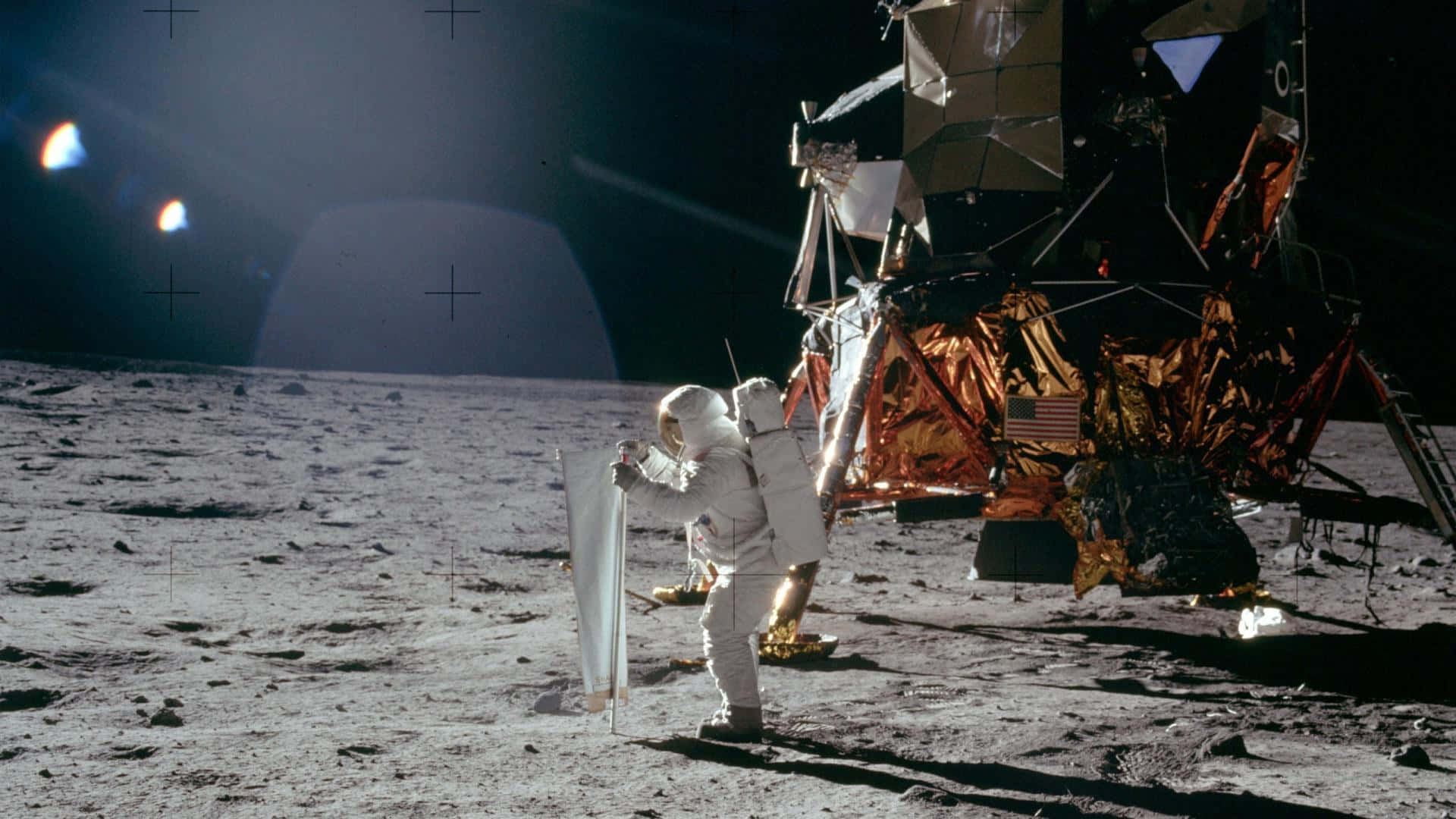 Neil Armstrong 桌布 壁紙 — 一名太空人在黑色的天空下，在月球灰色的表面上，在一個覆蓋著金箔的月球模塊旁邊插上一面旗幟，地球清晰可見。