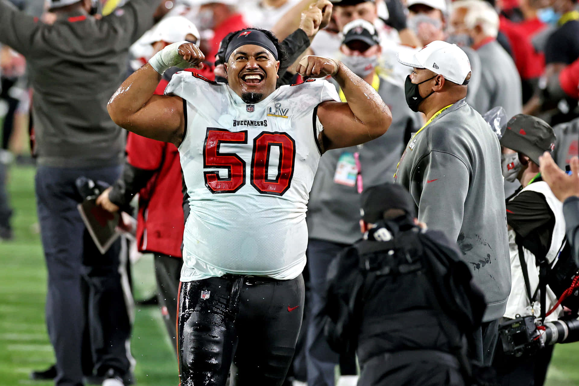  壁紙 — 坦帕灣海盜隊美式足球員身穿50號球衣，在勝利後於球場上得意地擺姿勢，背景有球迷歡呼。