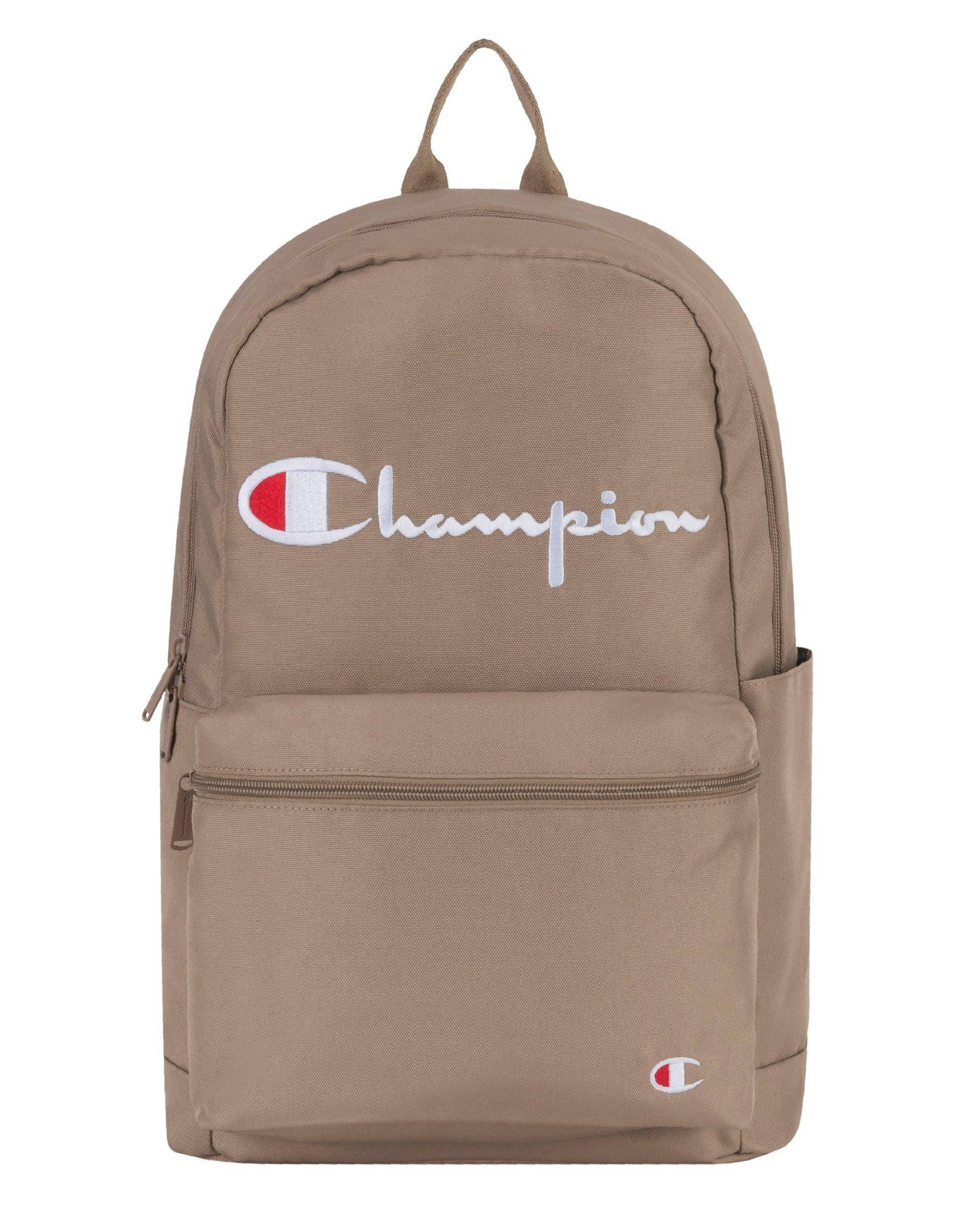 Champion 桌布 壁紙 — Tan Champion 後背包，帶有白色草書標誌和紅色徽章，背景為純白色。