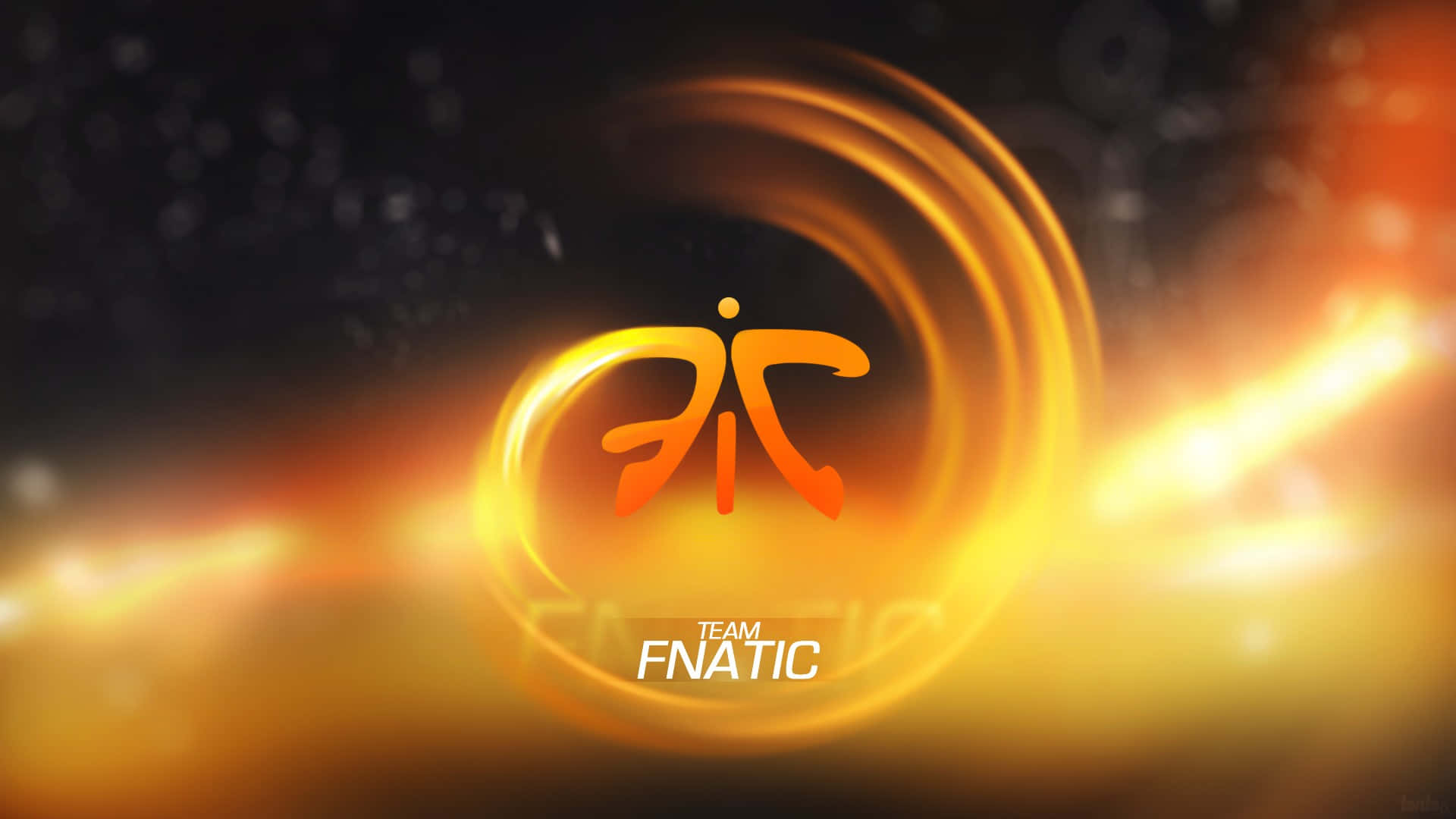 Tsm 桌布 壁紙 — Team Fnatic 標誌在黑暗背景上發出熾熱的橙色光芒，並帶有放射狀鏡頭光暈。