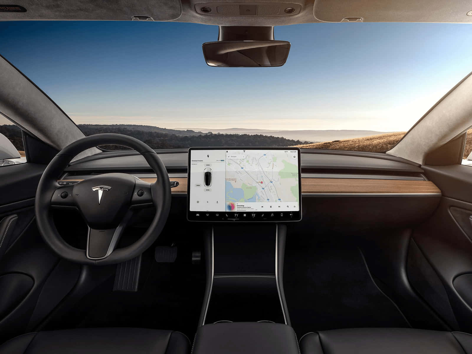 Tesla Model 3 桌布 壁紙 — Tesla 汽車內部，配備大型觸控螢幕，在日落時分顯示導航，背景是風景如畫的沙漠景觀。