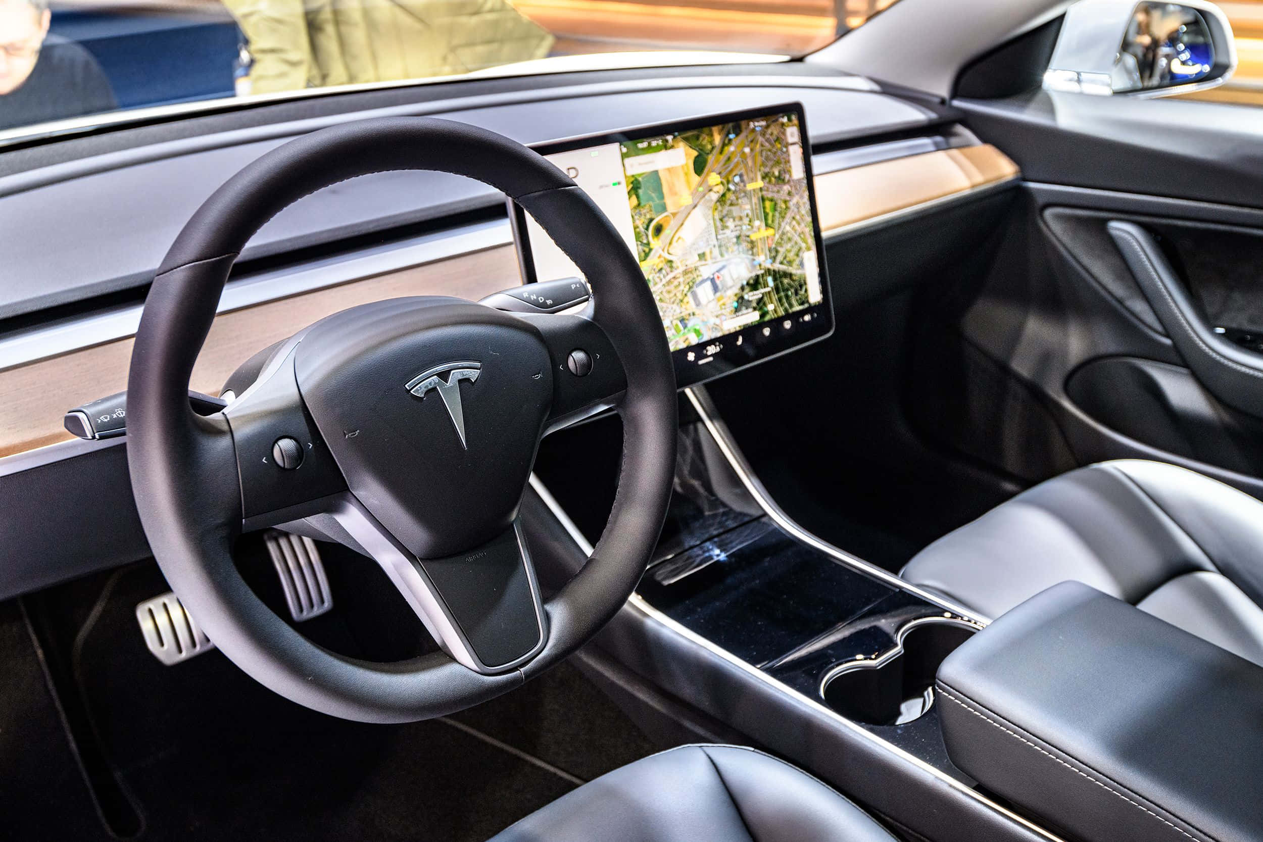 特斯拉 桌布 壁紙 — Tesla 車廂內部特寫，展示時尚黑色方向盤和大型中央觸控螢幕。