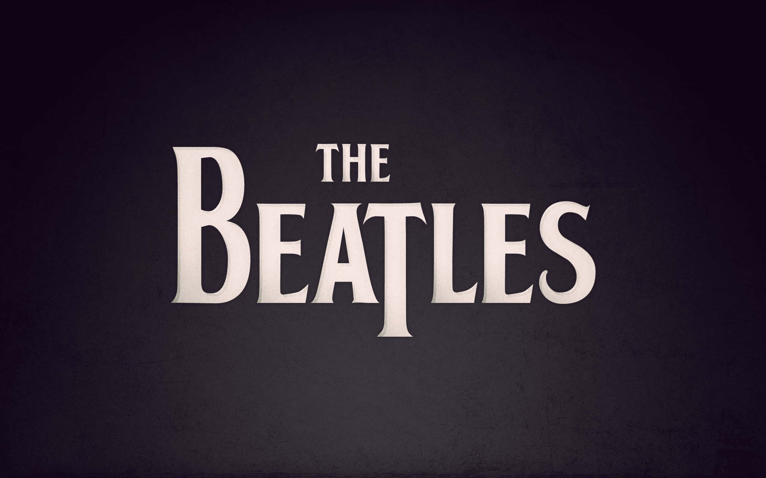 the beatles 桌布 壁紙 — The Beatles 標誌以粗體白色襯線字體居中顯示在紋理深灰色背景上。