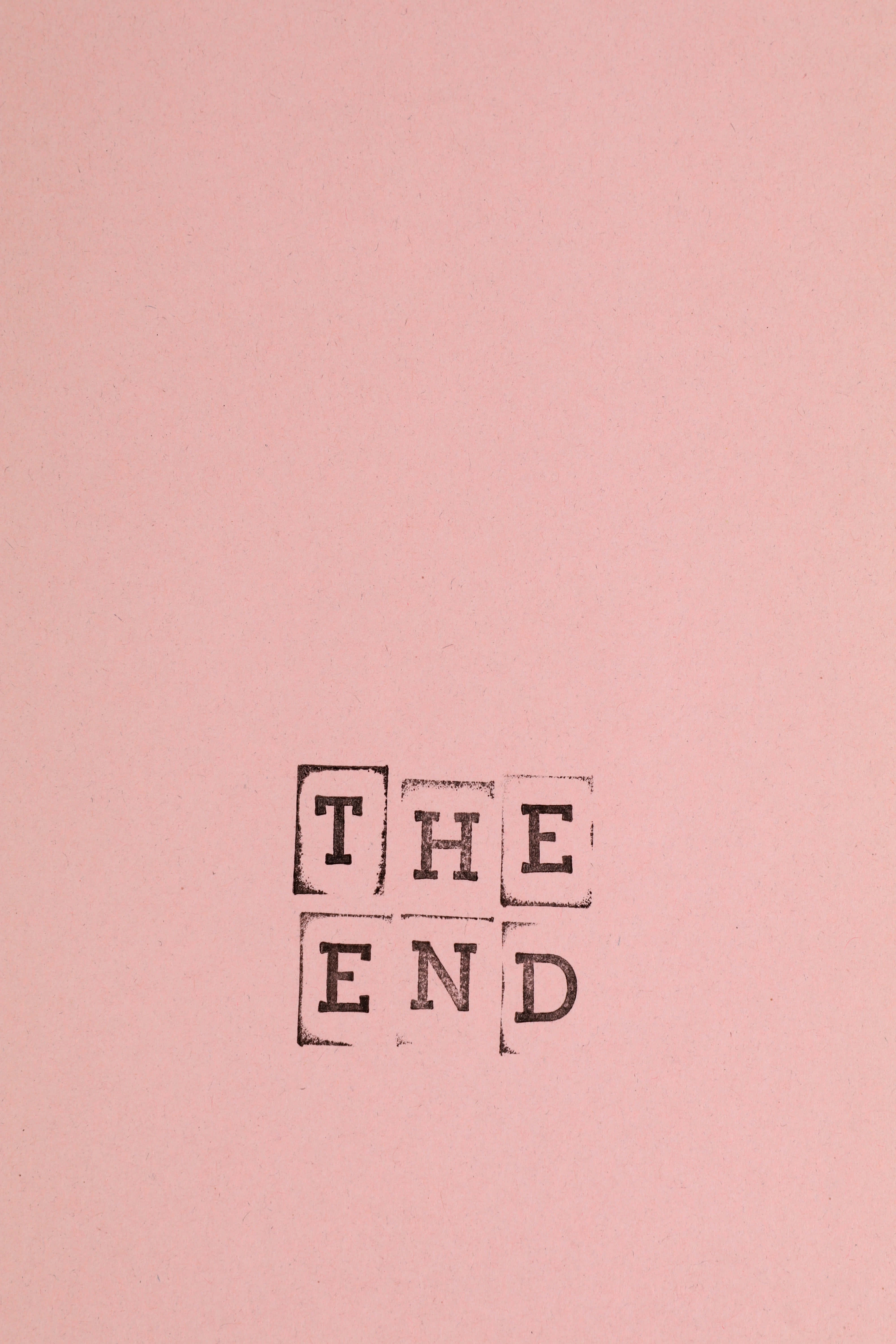 the end 桌布 壁紙 — 「THE END」這幾個字用黑色墨水印在有紋理的粉紅色紙上，設計簡約。