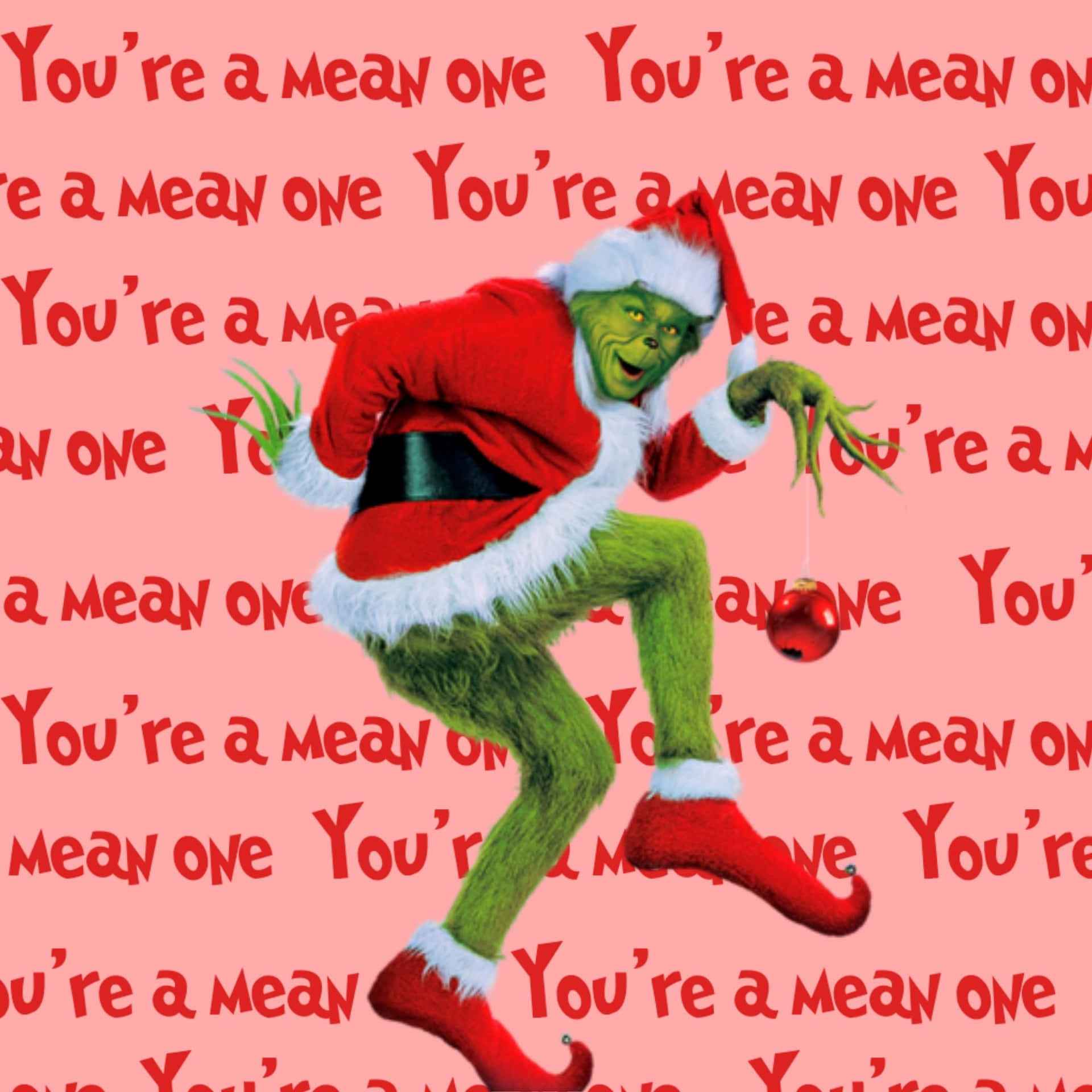  壁紙 — 聖誕怪傑穿著紅色聖誕老人套裝，在覆蓋著重複紅色文字的粉紅色背景上歡快地跳舞。