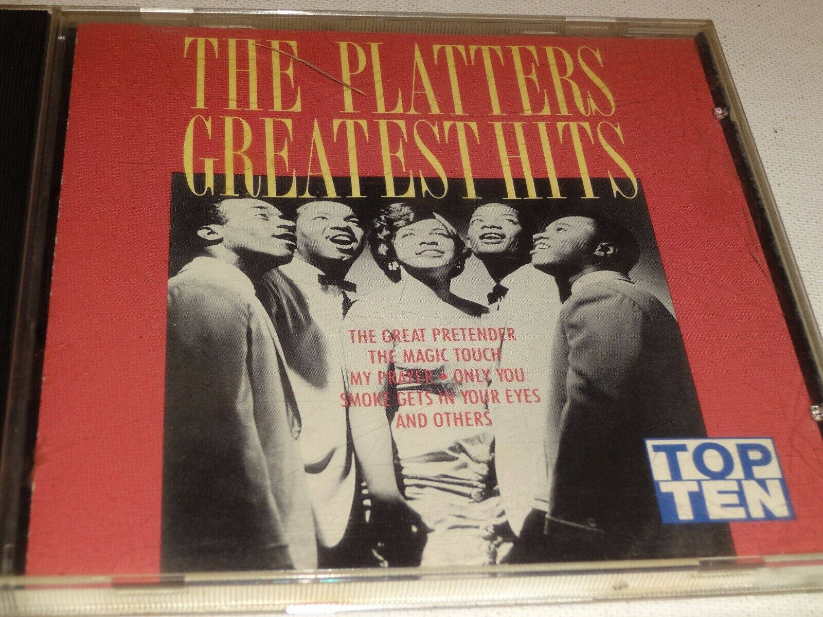 Famous 桌布 壁紙 — The Platters Greatest Hits 的復古CD封面，以黑白照片展示團體在鮮紅色背景上唱歌。