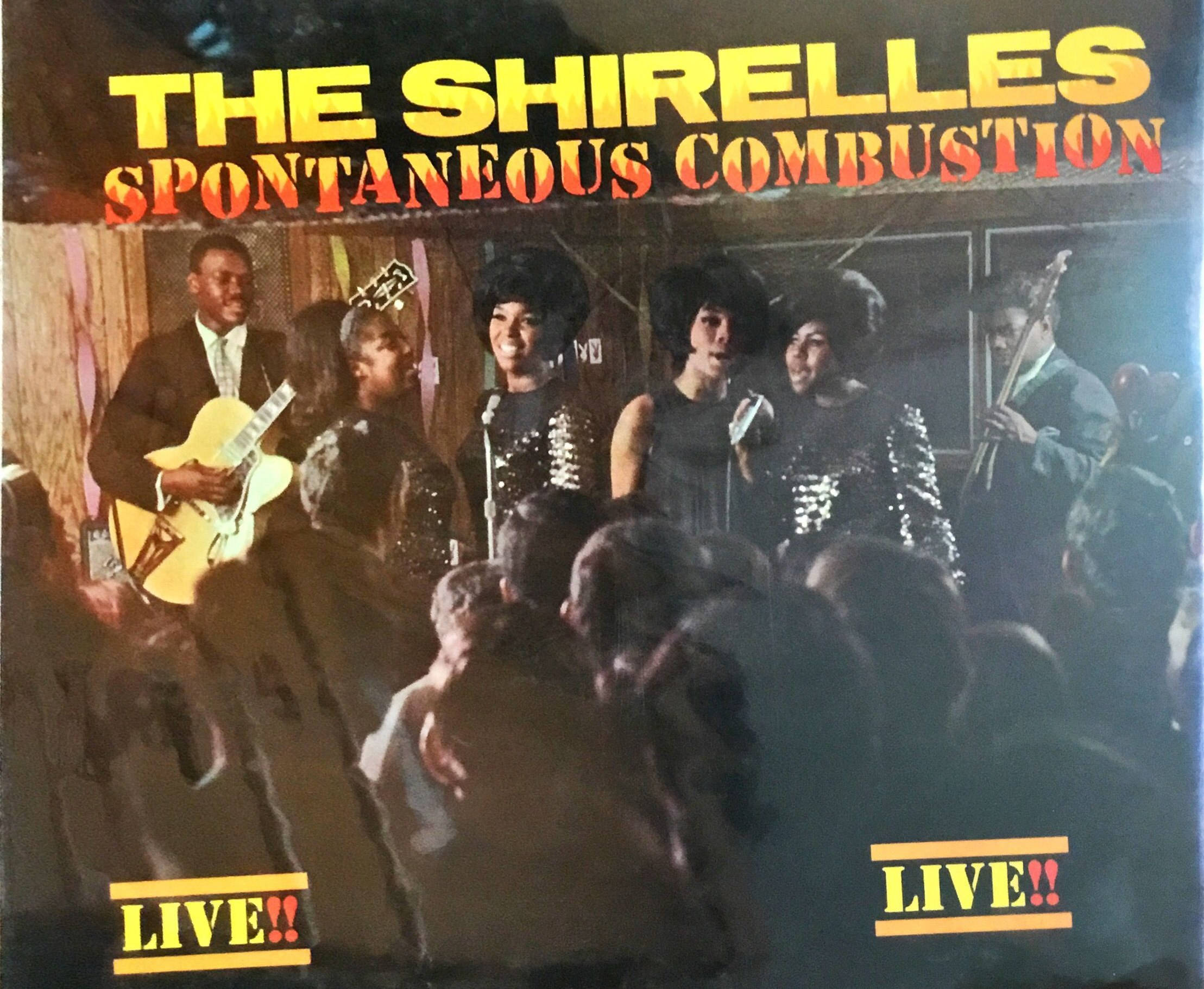 Album Cover 桌布 壁紙 — The Shirelles 的復古現場表演海報，描繪樂團和人群在溫暖的舞台燈光下。