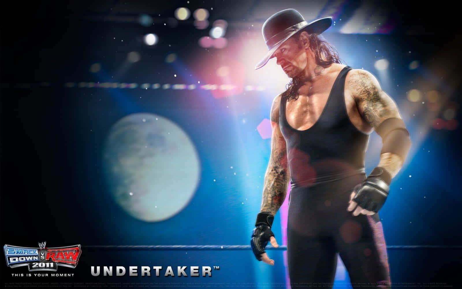 WWE 桌布 壁紙 — The Undertaker 在戲劇性的藍色燈光下，背景有發光的月亮，莊嚴地站在摔角擂台上。