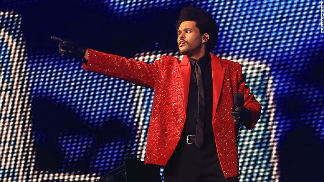 Red Coat 桌布 壁紙 — The Weeknd 在藍色像素背景前穿著閃亮紅色西裝外套表演。