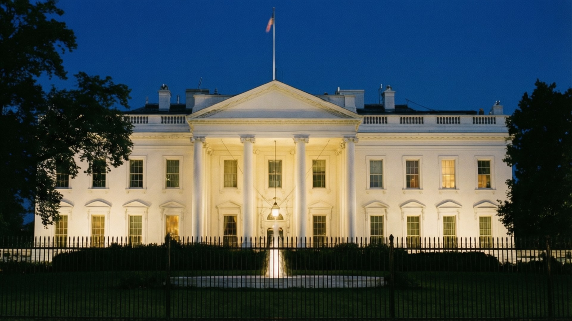 White House Night View 壁紙 — 白宮在夜間被照亮，溫暖的燈光從窗戶透出，映襯著深藍色的天空。