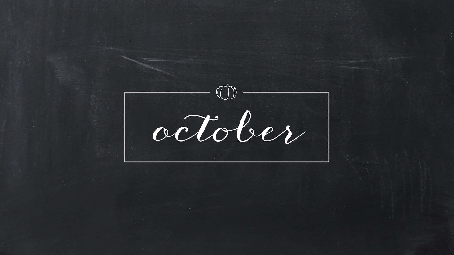 October Desktop 桌布 壁紙 — 「十月」這個詞用優雅的白色草書寫在一個薄矩形內，位於有紋理的黑色黑板上，上方有一個小南瓜。