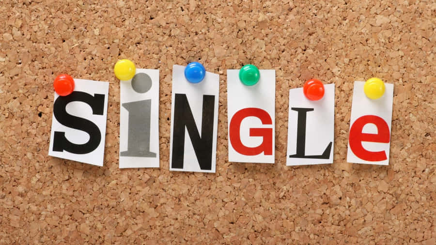  壁紙 — 「SINGLE」這個字用彩色剪紙字母釘在軟木板上。