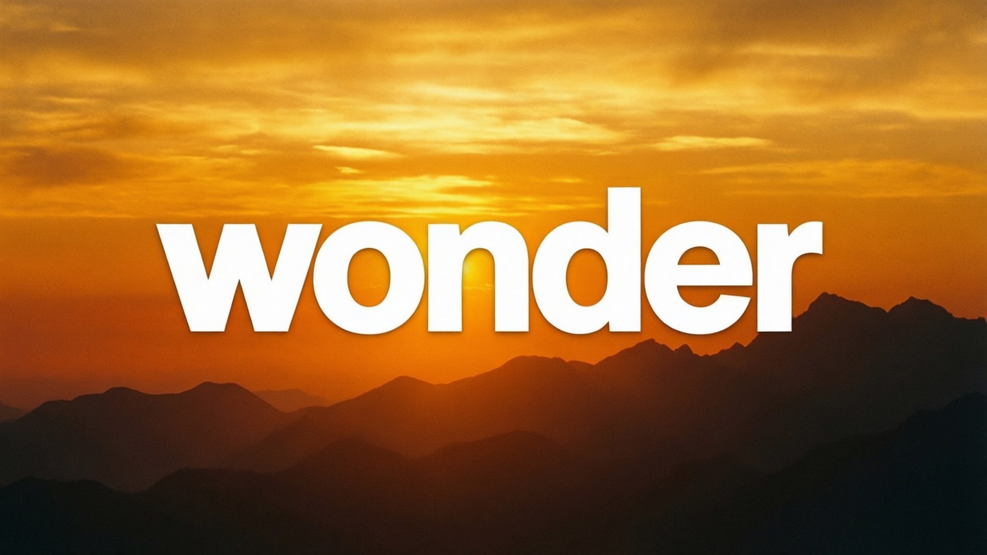 美學字眼 桌布 壁紙 — 「wonder」一詞以粗體白色字體浮現在層層山巒剪影之上的火熱橙色日落背景中。