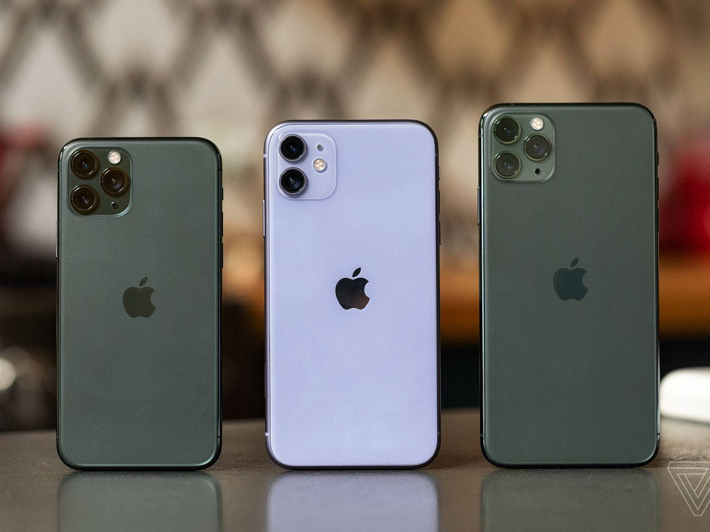 三款Apple iPhone展示在反光表面上。 — iPhone 13 Pro Max 壁紙