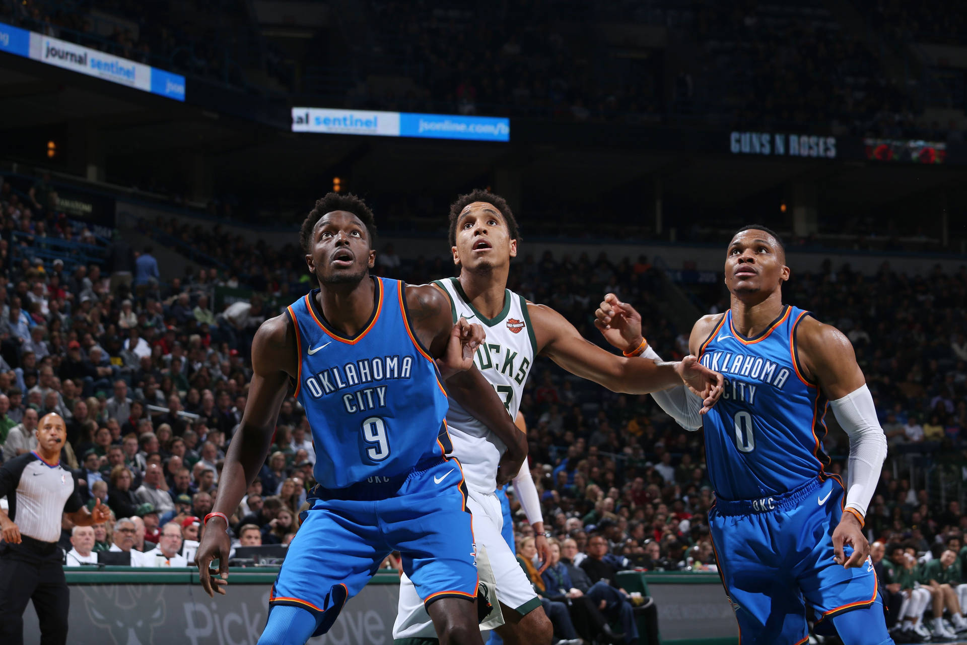 三名籃球運動員在NBA比賽中，背景有觀眾，正在進行動作。 — NBA 壁紙