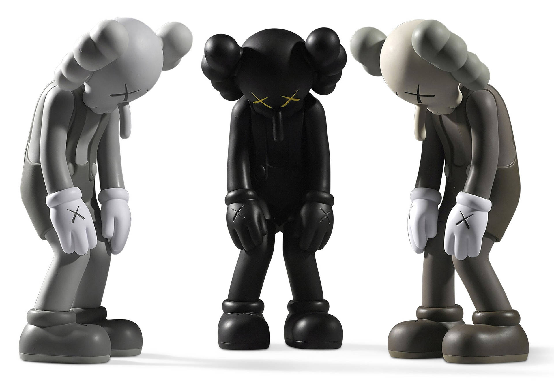 三個KAWS Companion雕像以灰色調低頭。 — Kaws 壁紙