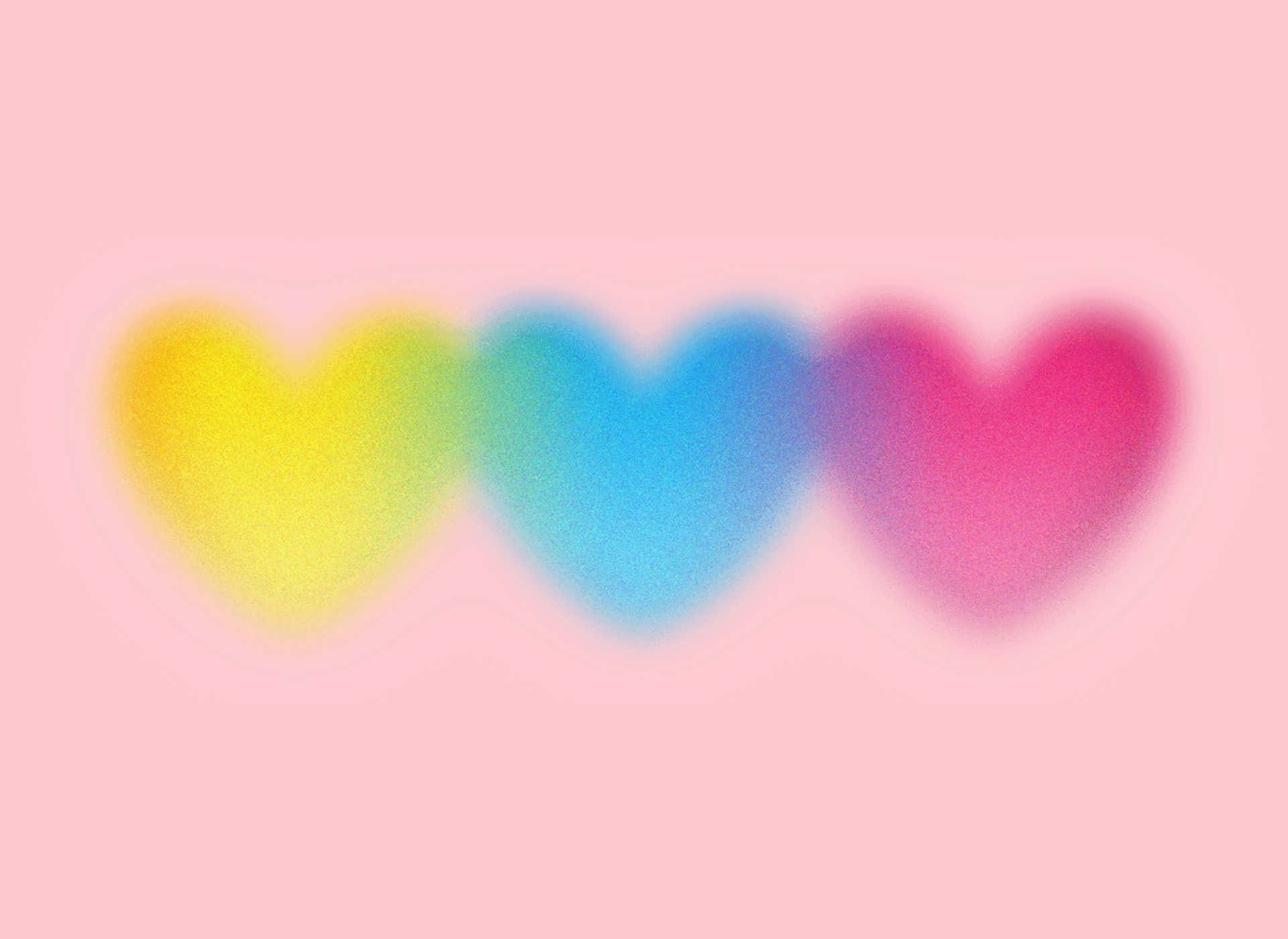  壁紙 — 三個柔和模糊的心形，分別是黃色、藍色和粉紅色，在粉彩粉紅色的背景上輕輕發光。