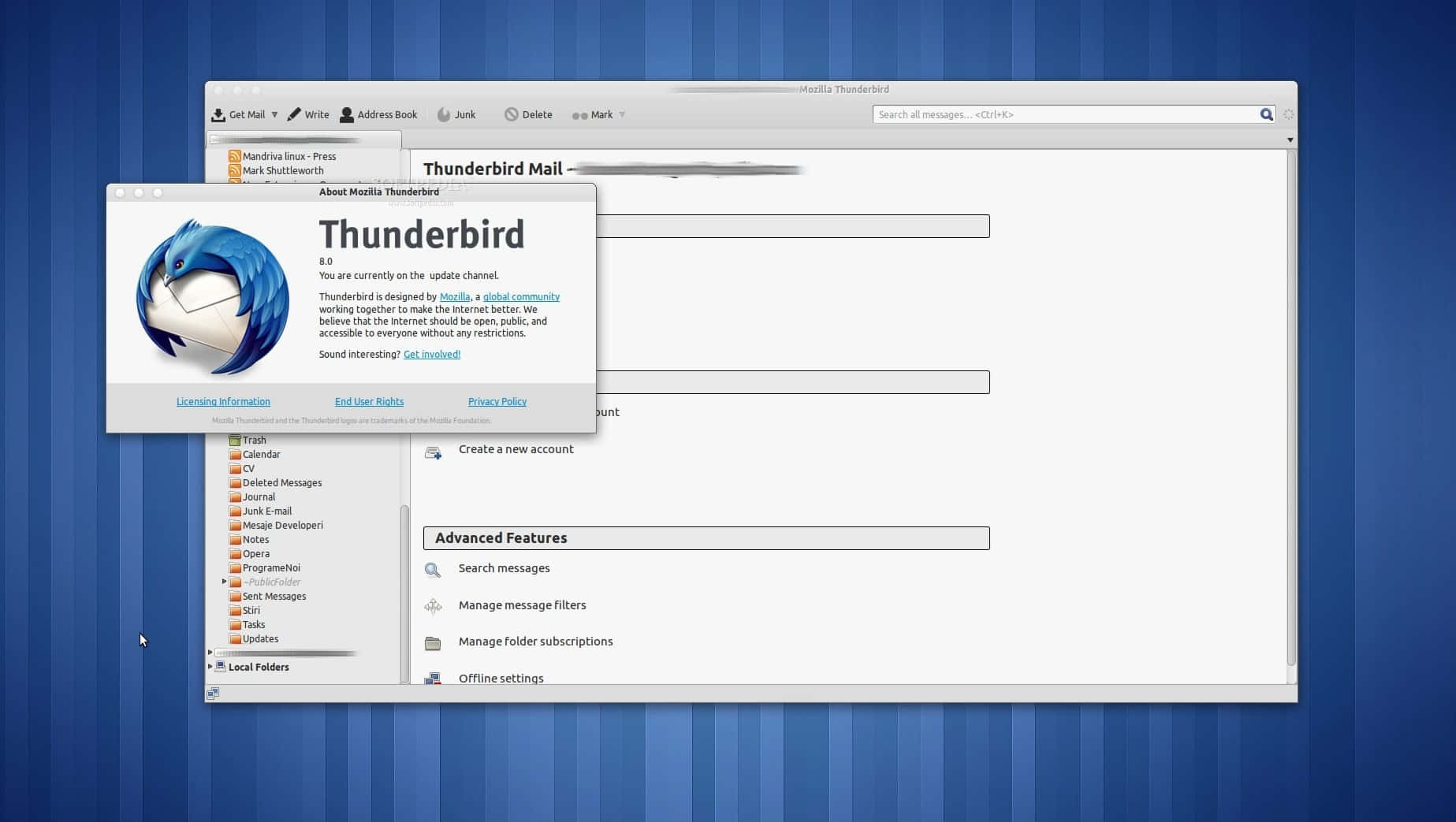 Thunderbird 桌布 壁紙 — Thunderbird Mail 應用程式視窗在藍色條紋桌面背景上開啟，顯示關於對話框和側邊欄資料夾。